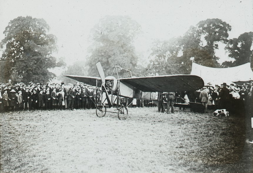 A monoplane preparing for flight from Great Windsor Park surrounded by many spectators.