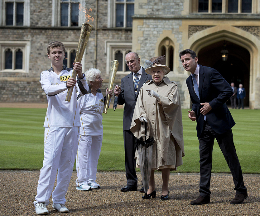 Queen Elizabeth II outside Windsor Castle with representatives from the London Olympics and the Olympic torch