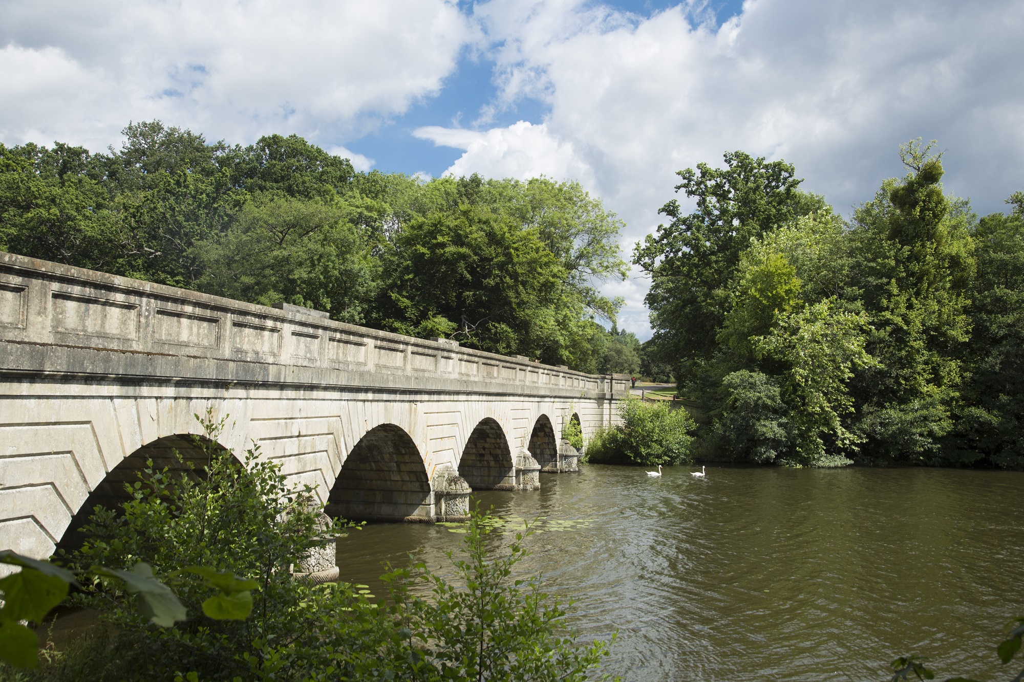 Five Arch Bridge at Virginia Water Lake with trees in the background.