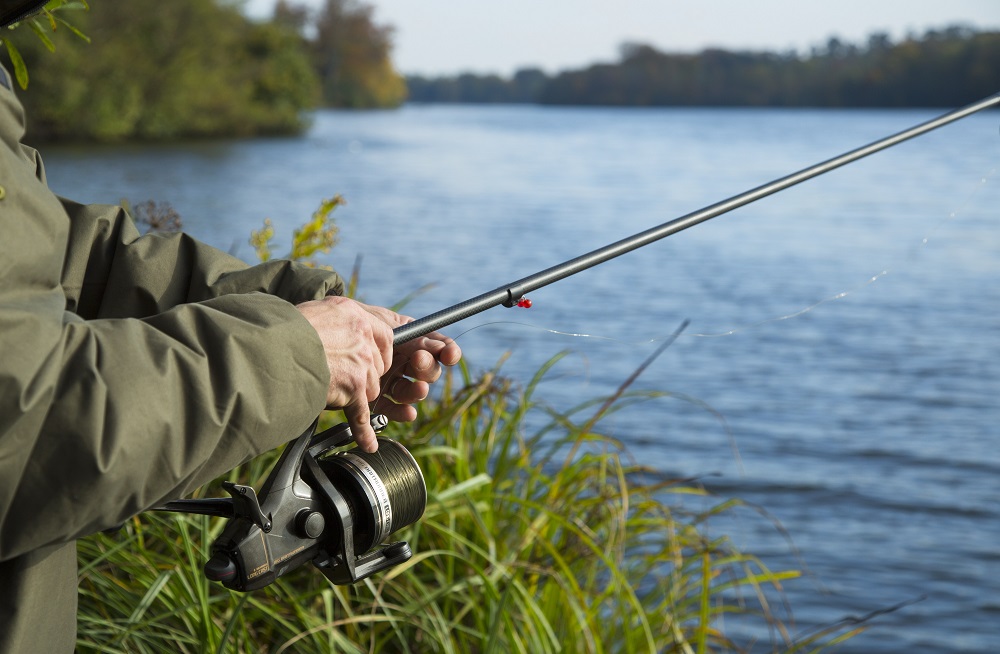 Angler holding a fishing rod at Virginia Water Lake.
