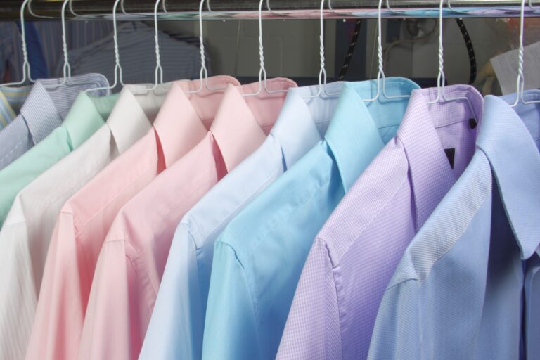 Ironed shirts in different colours on hangers.