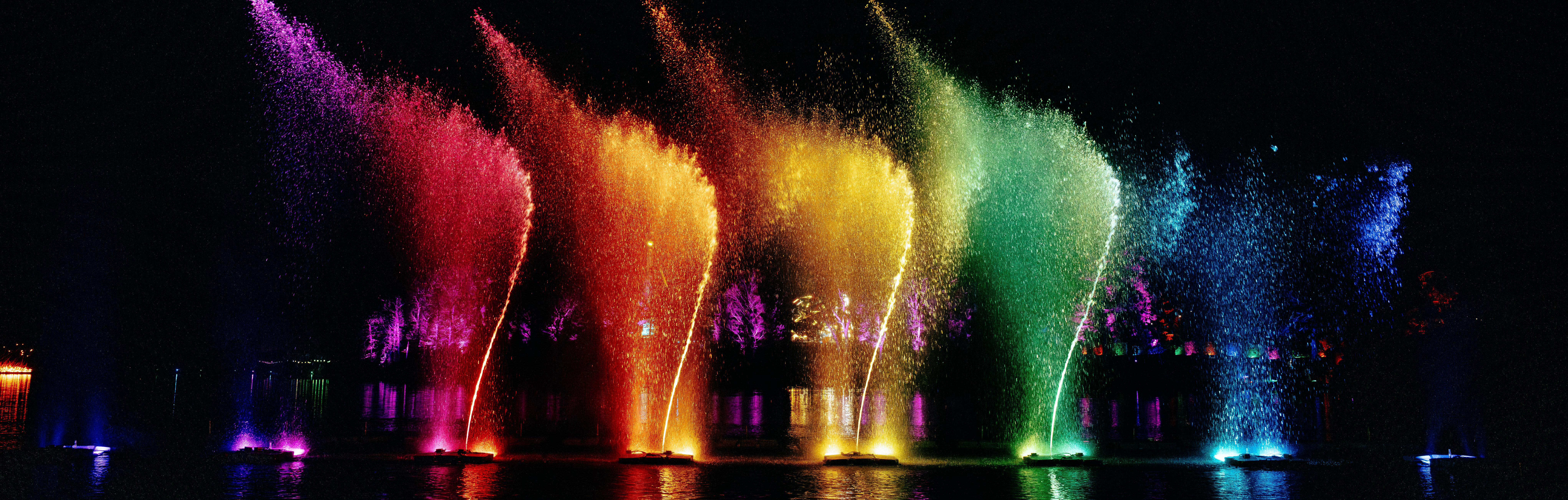 Multi coloured water fountains at night.