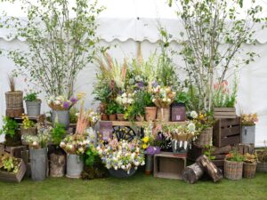 A range of flowers and bouquets presented in metal urns, buckets, wooden boxes and terracotta pots.
