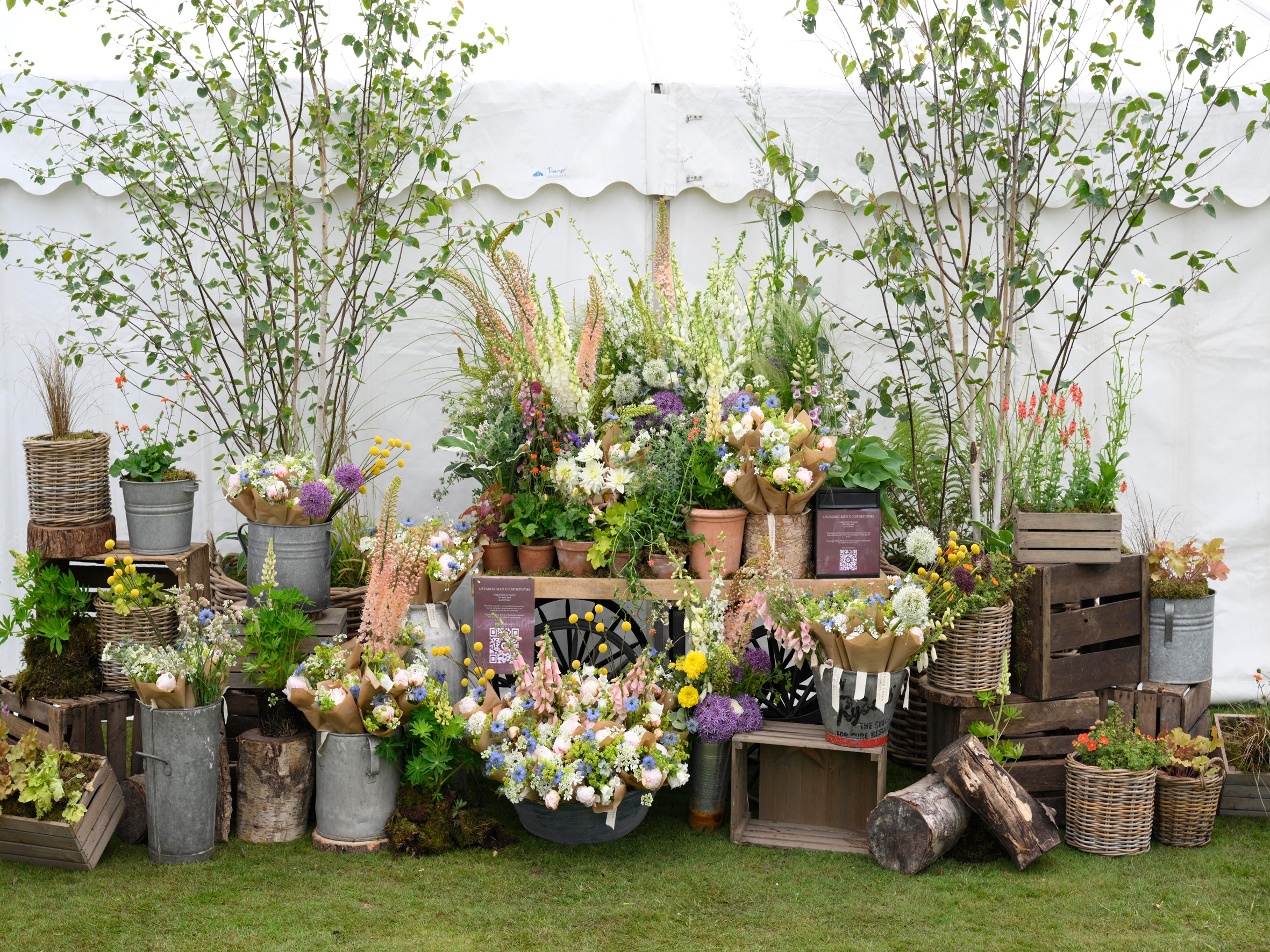 A range of flowers and bouquets presented in metal urns, buckets, wooden boxes and terracotta pots.