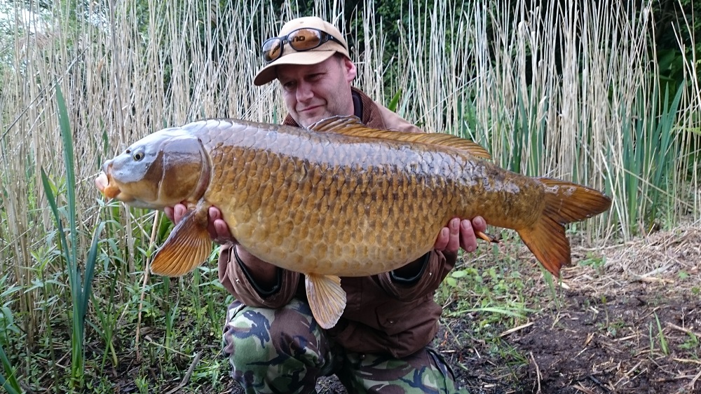 Angler with a carp at Virginia Water Lake.