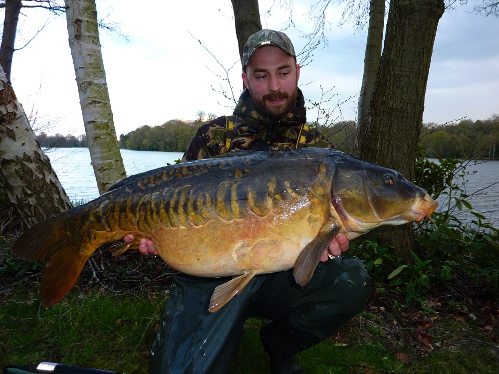 Angler with a carp at Virginia Water Lake.