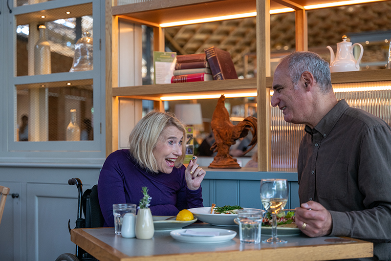 Two people sitting at a table and eating a meal.