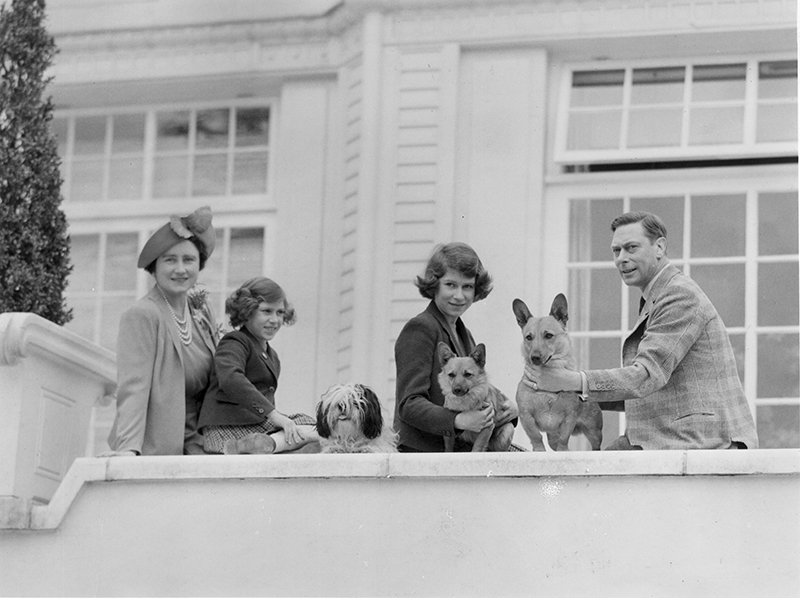 A photograph of King George VI, Queen Elizabeth, Princess Elizabeth and Princess Margaret outside the Royal Lodge.