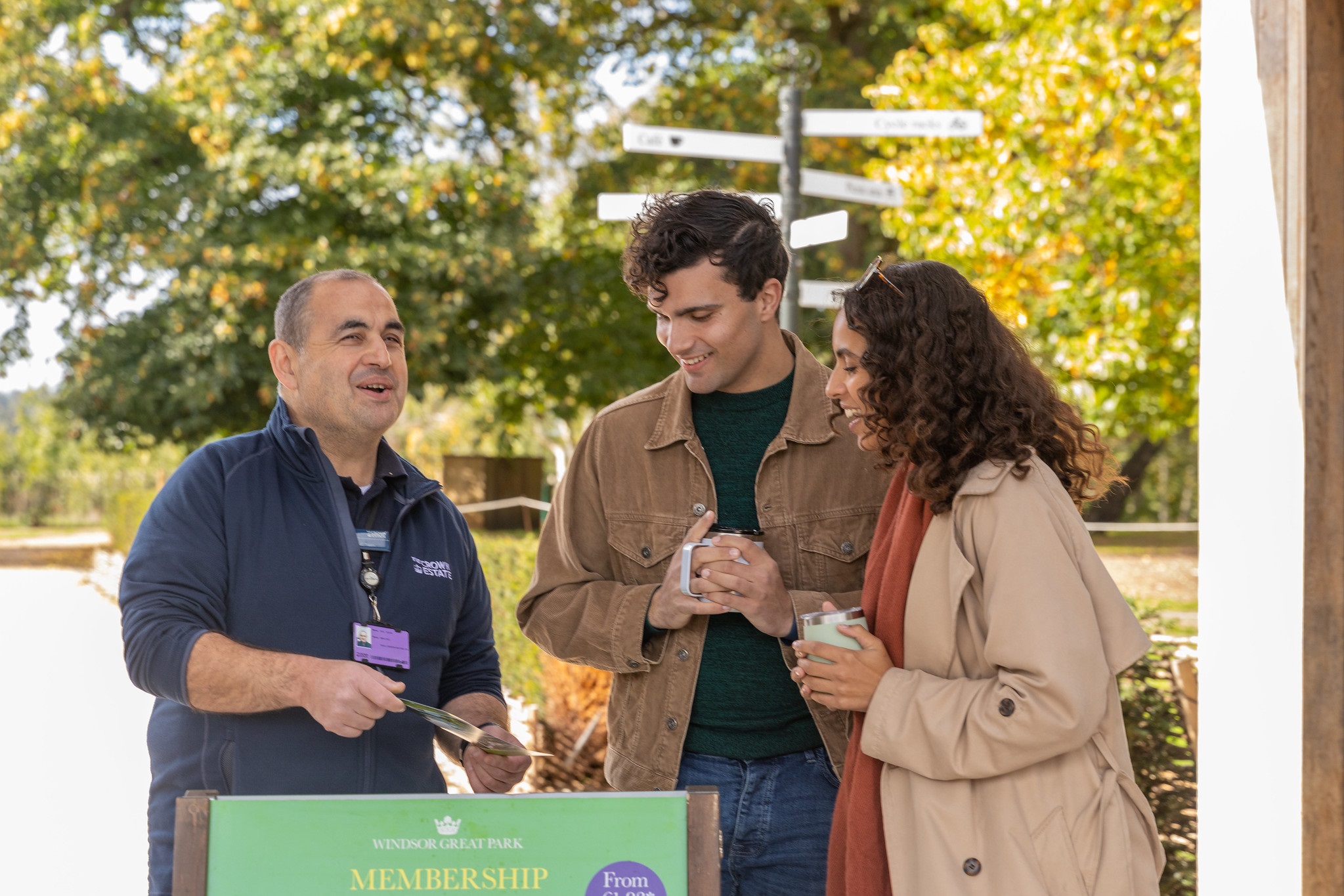 Two adults talking to a member of staff at the Virginia Water Gift Shop.