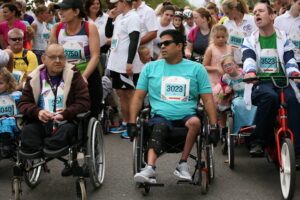 Two adult wheelchair users surrounded by other event participants at Parallel Windsor.