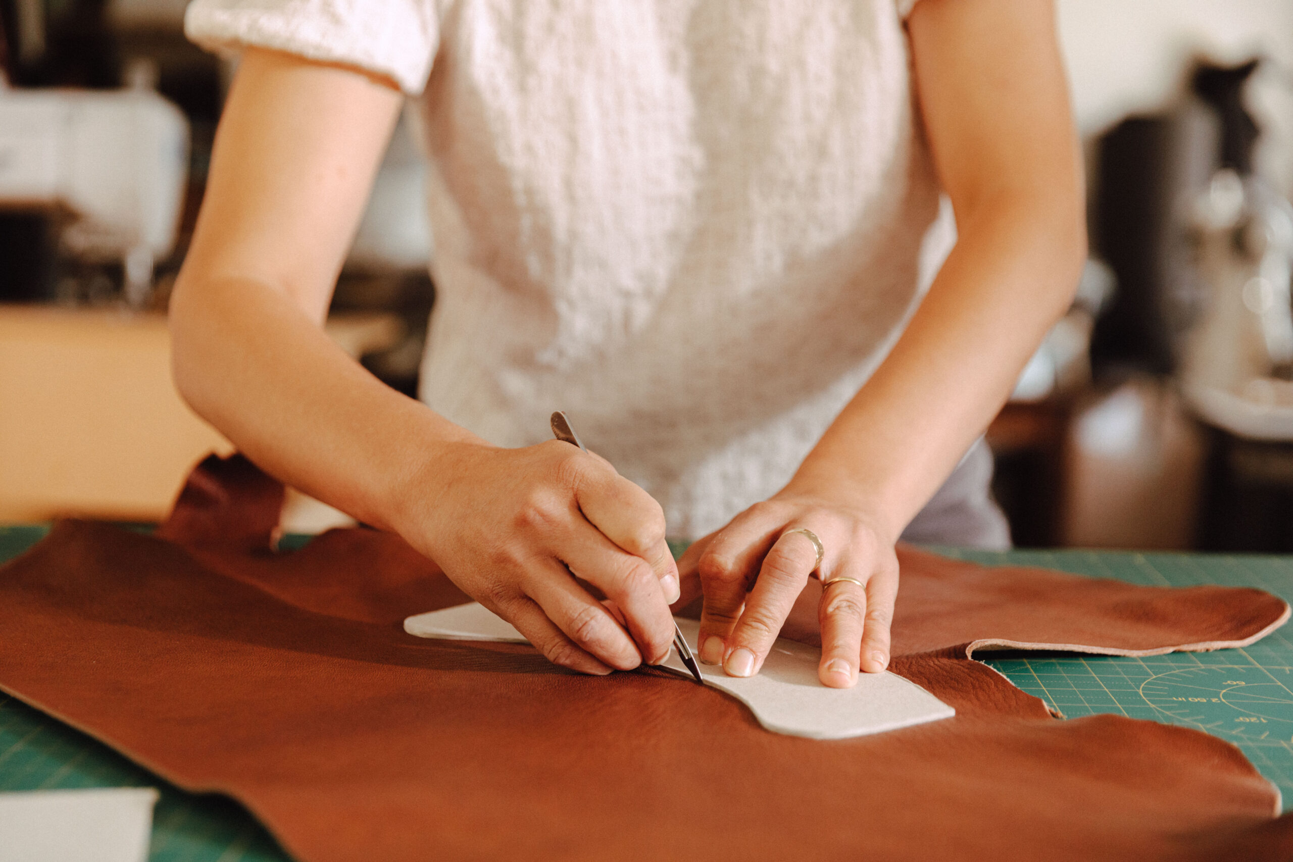 Person using a template to cut leather.