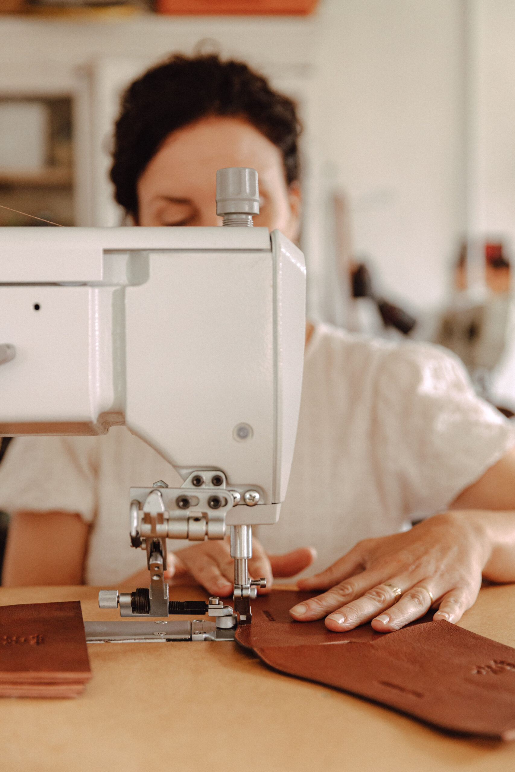 Person hand sewing leather.