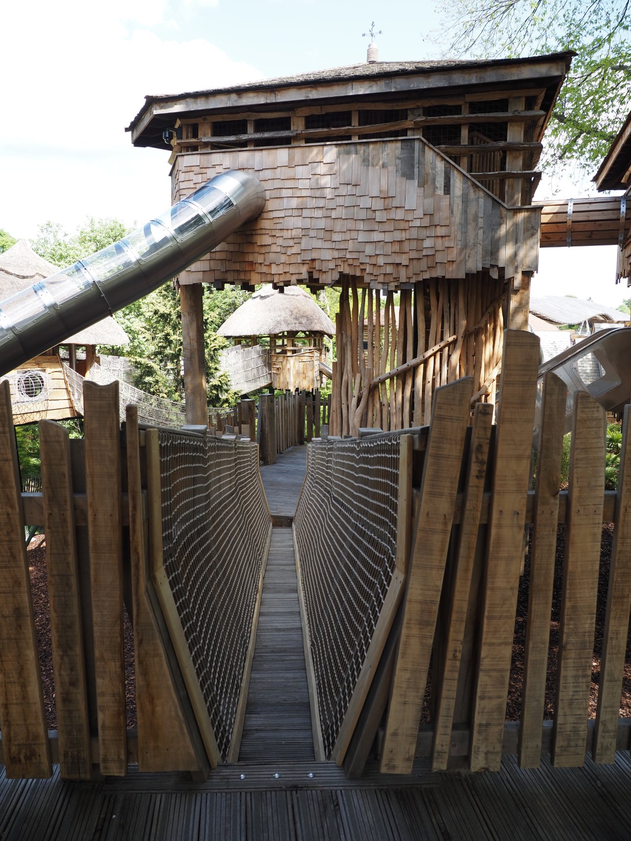 A row of adults standing with their woven willow pyramids.