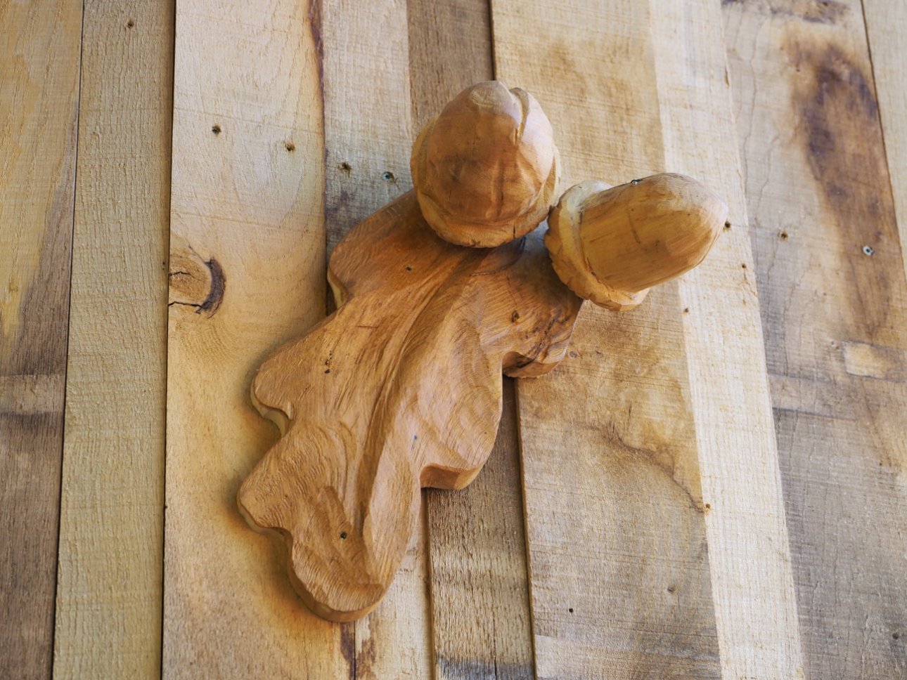 Carved wooden acorns attached to the side of a wooden building.