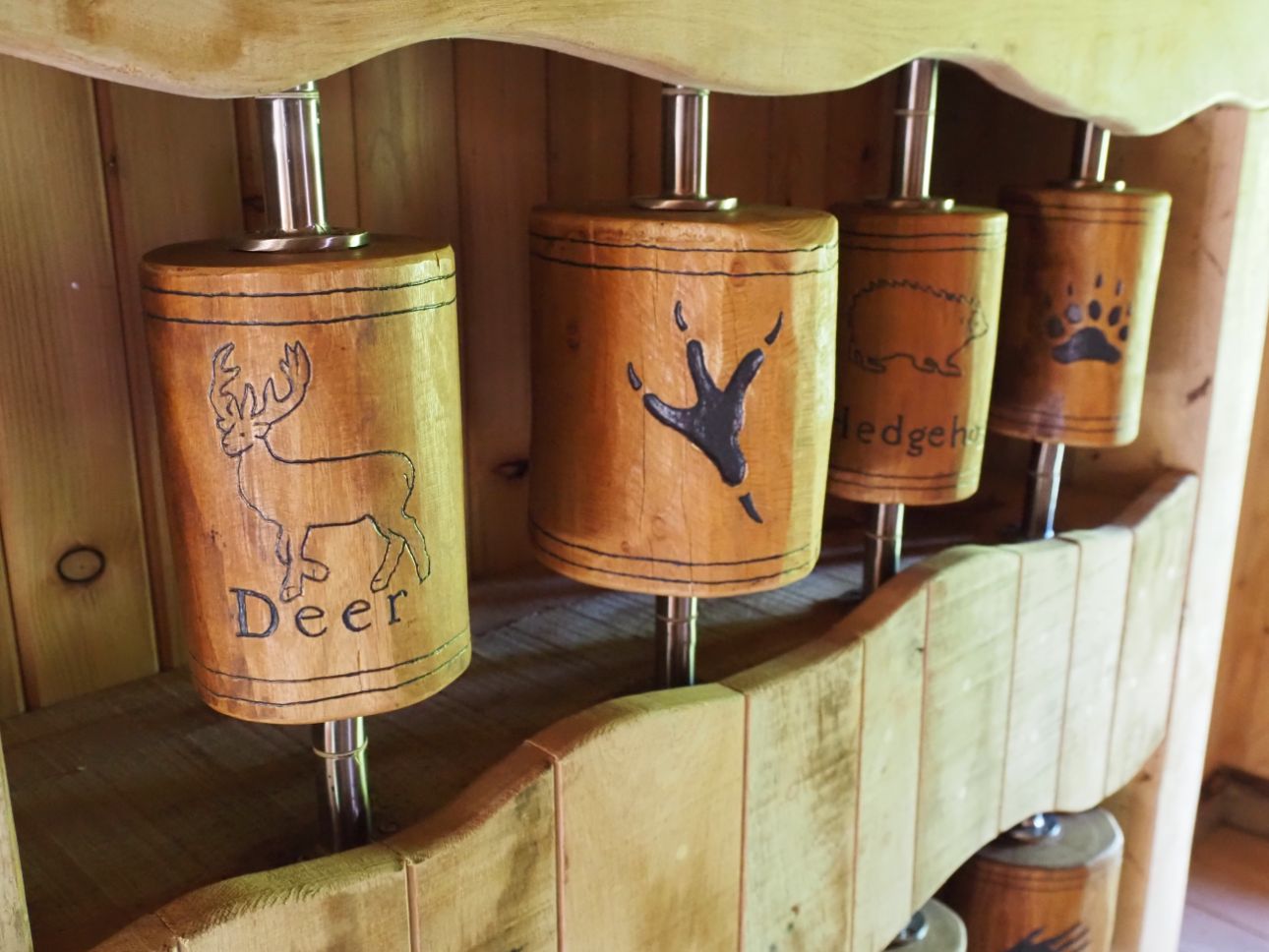 Wooden spinners with carvings of animals and footprints.