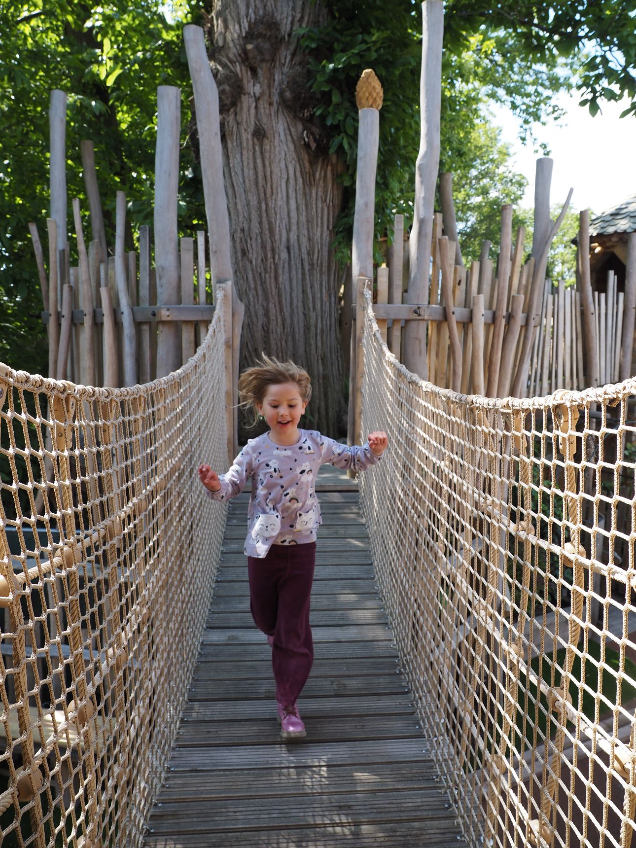 A row of adults standing with their woven willow pyramids.