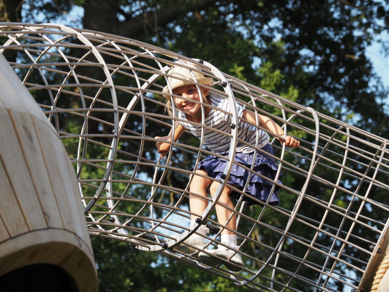 Young child climbing through a wire frame.