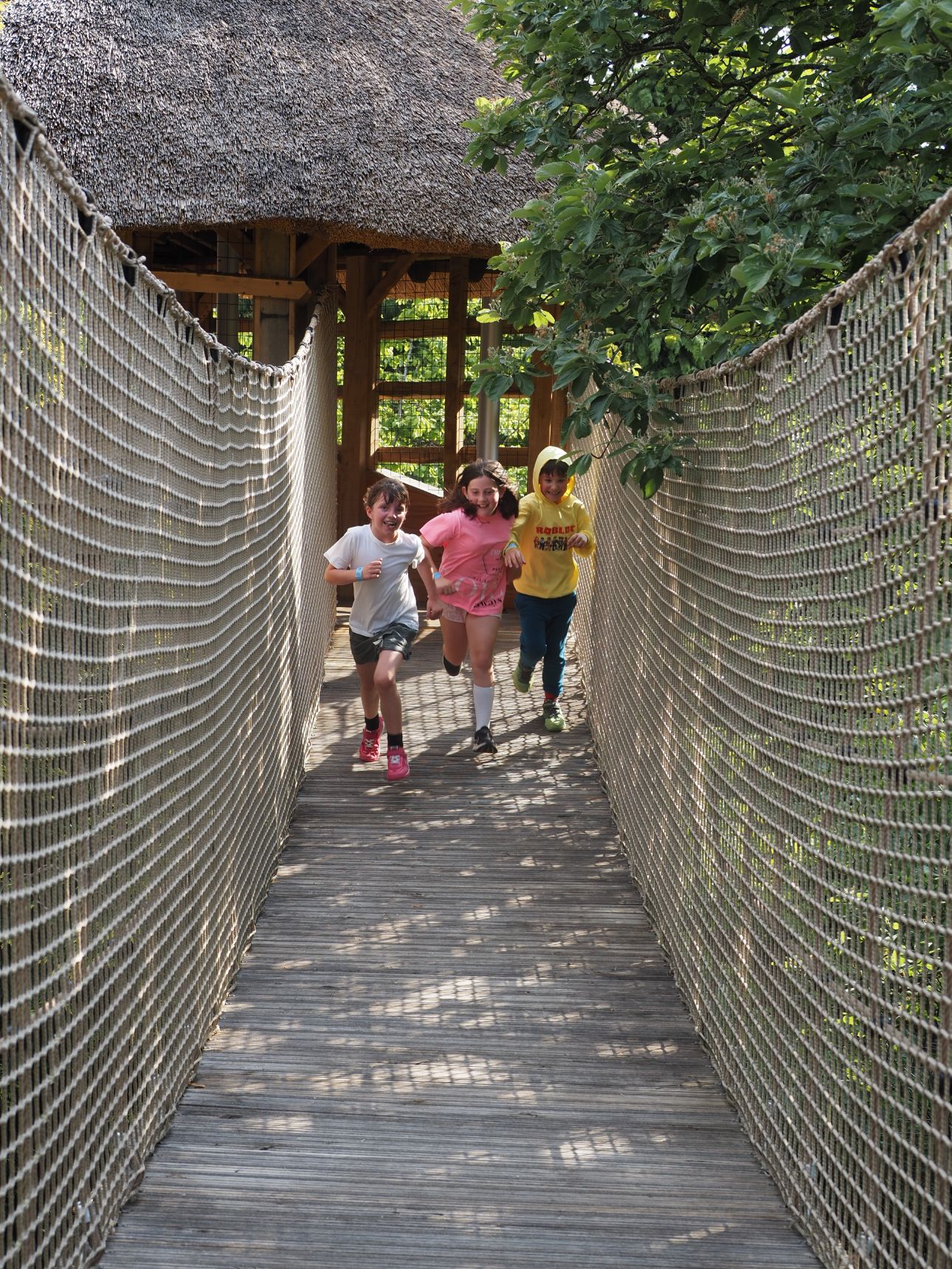 A row of adults standing with their woven willow pyramids.