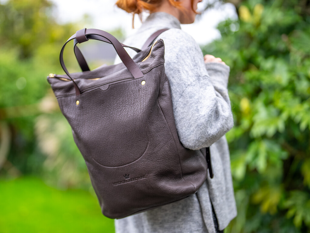 Adult holding a Billy Tannery leather backpack branded Windsor Great Park.