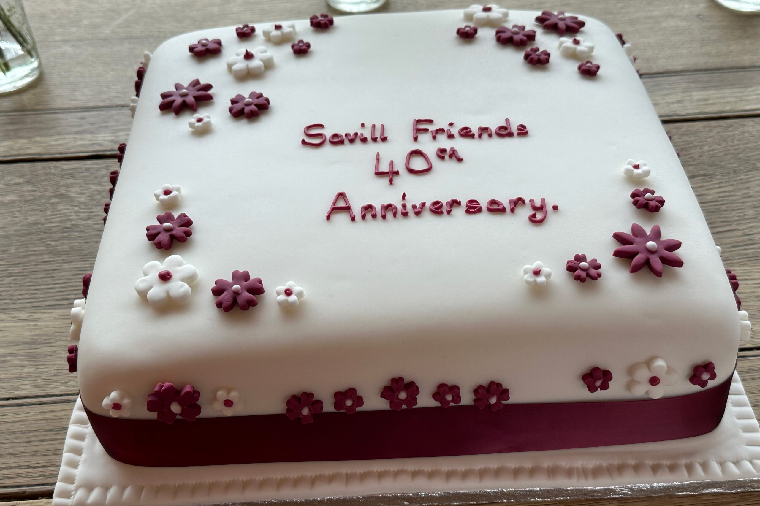 A homemade cake with royal icing that reads 'Savill Friends 40th Anniversary'.
