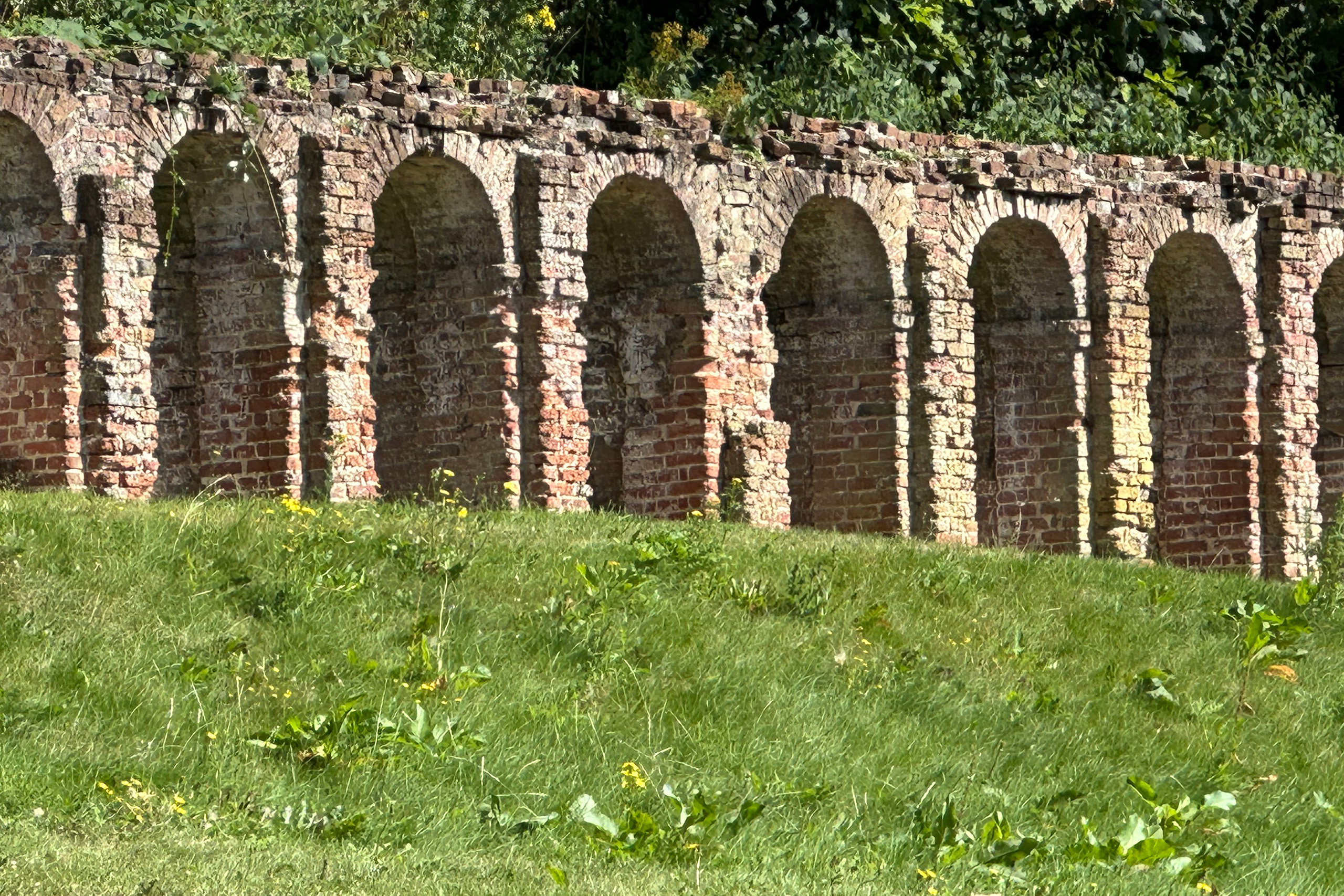 A stone wall on a grass lawn.