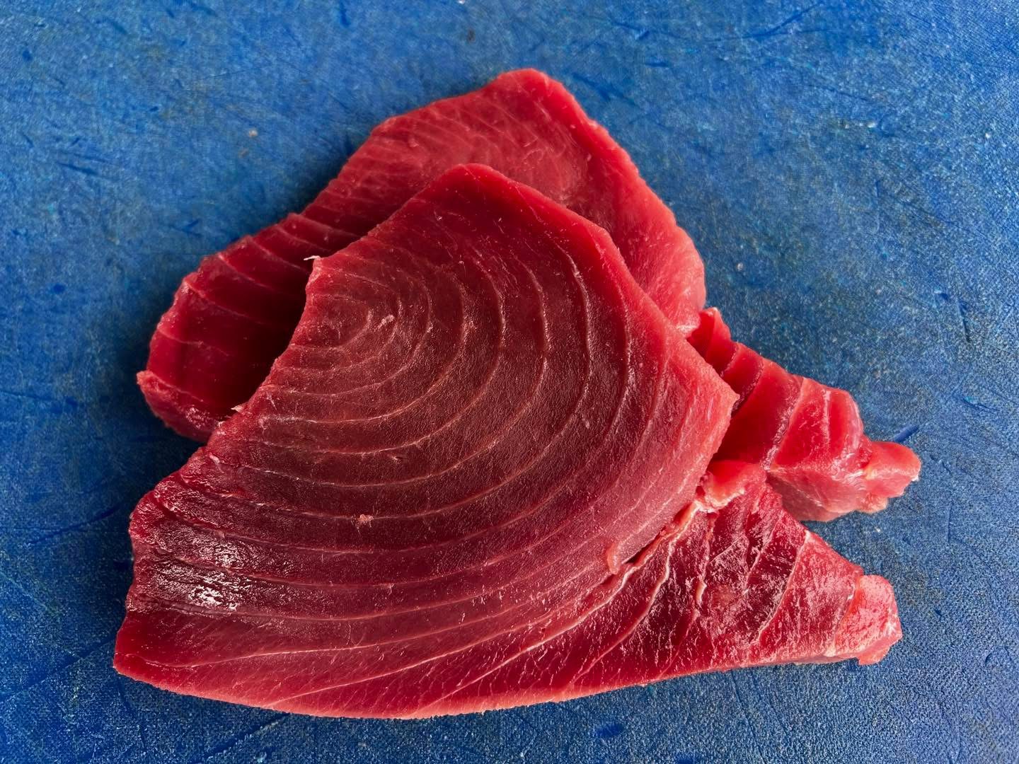 Slices of Tuna on a blue board.