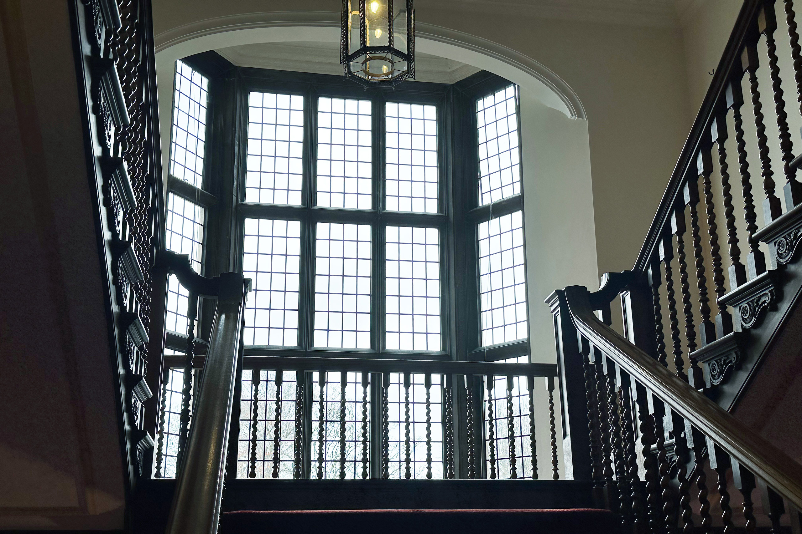 A large window flanked by a wooden staircase on both sides.