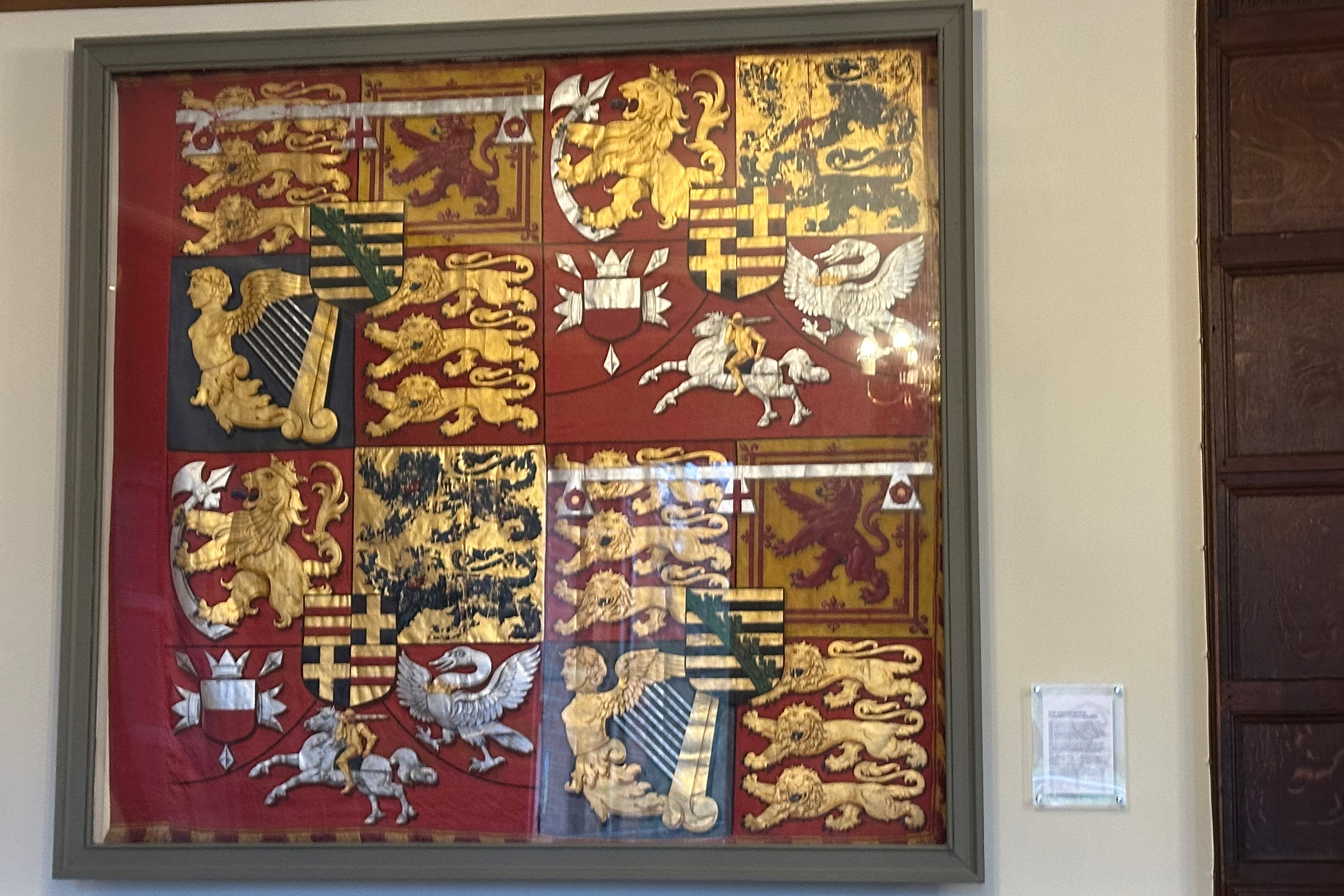 A square red banner of heraldic symbols.