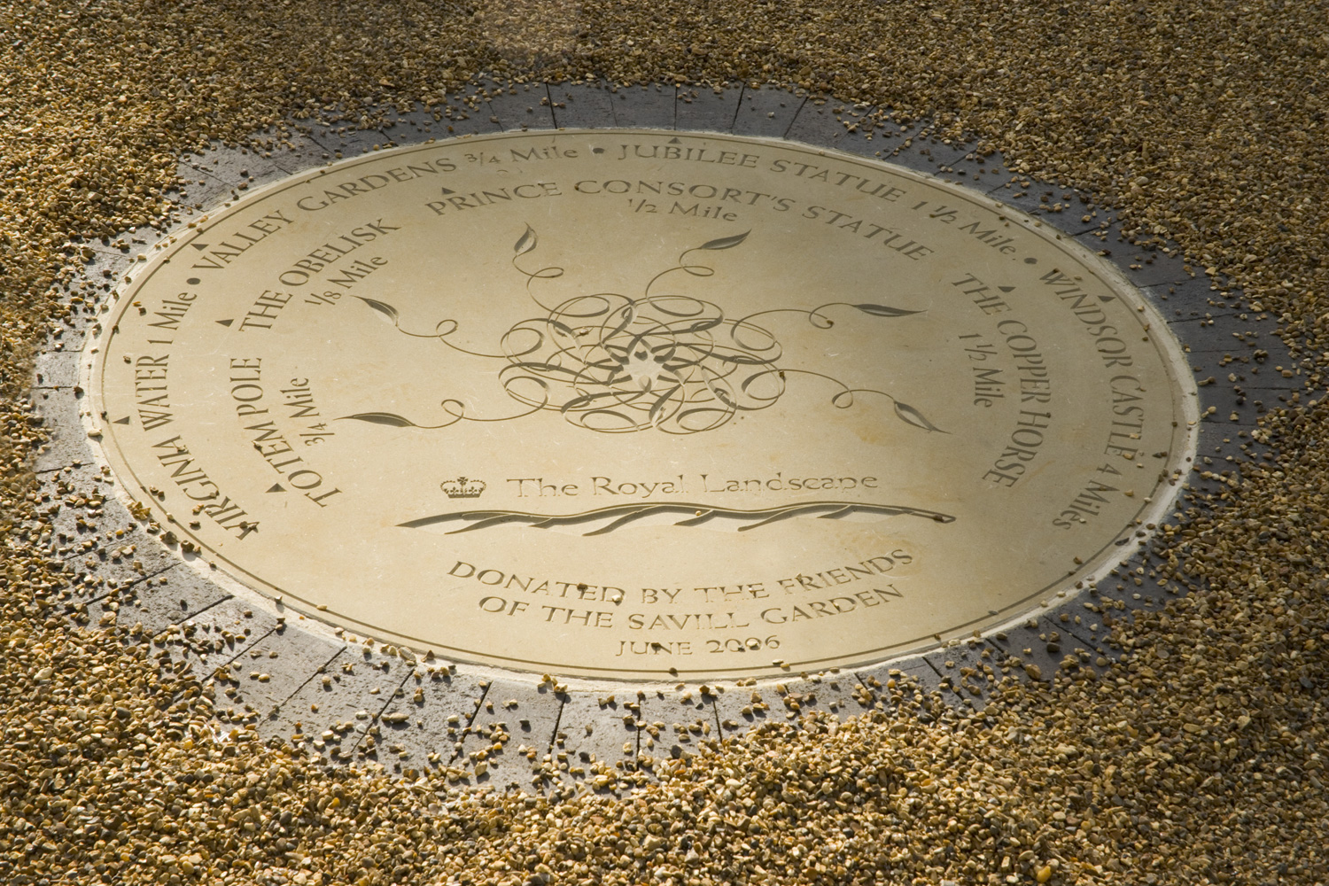 A circular plaque on the ground surrounded by gravel.