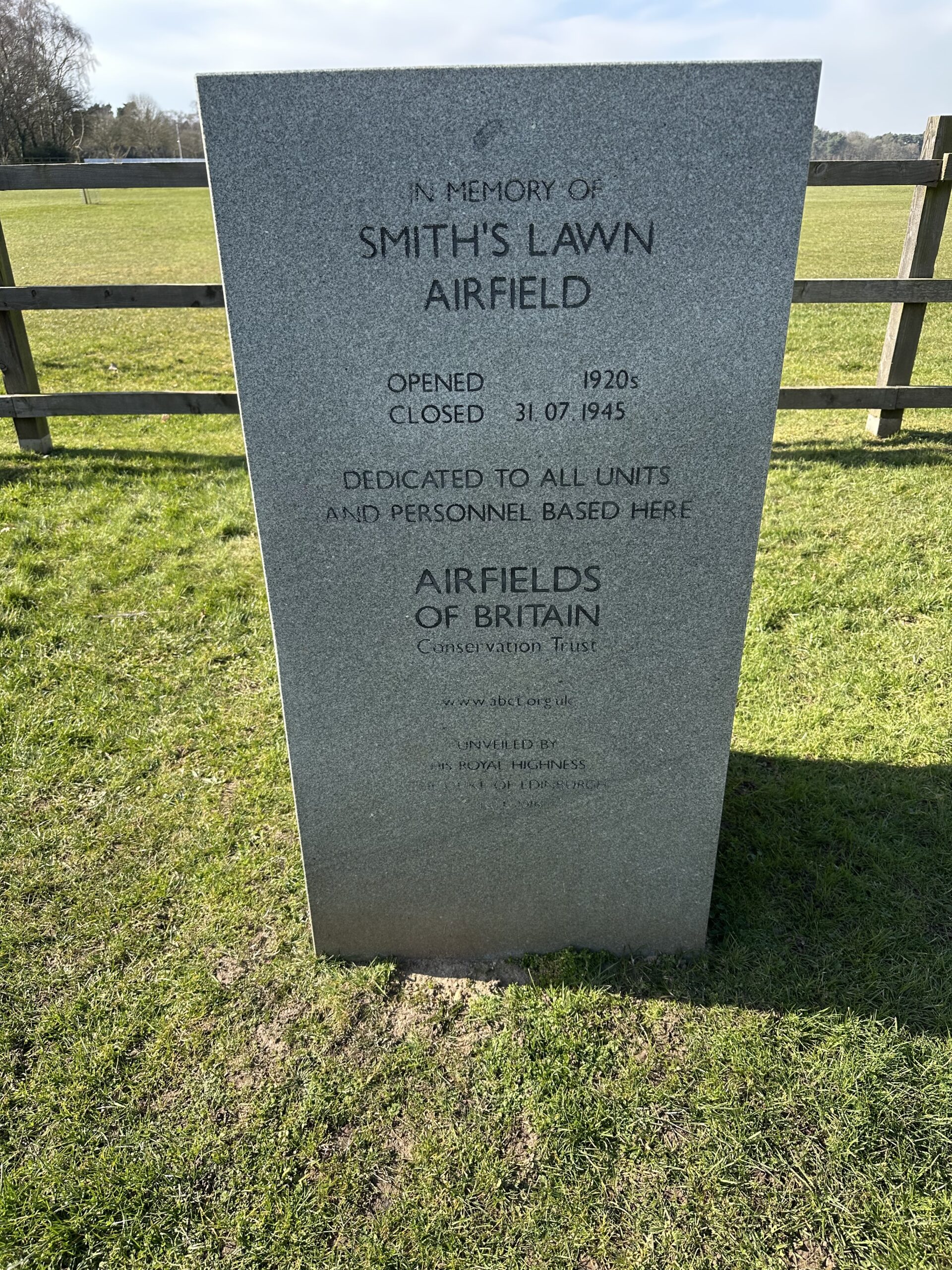 A stone plaque standing on a grassy lawn.