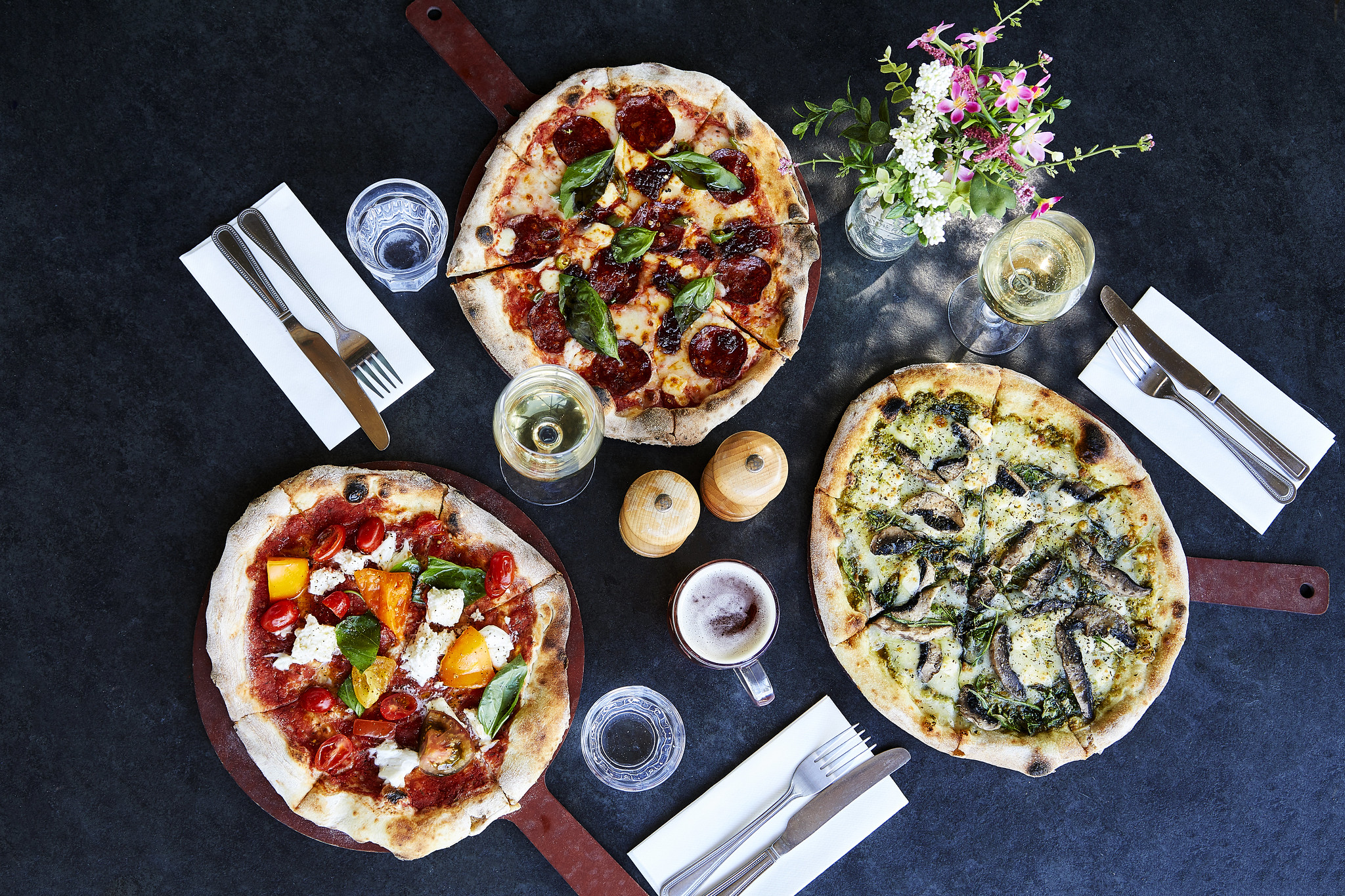 Aerial view of three pizzas on a table.