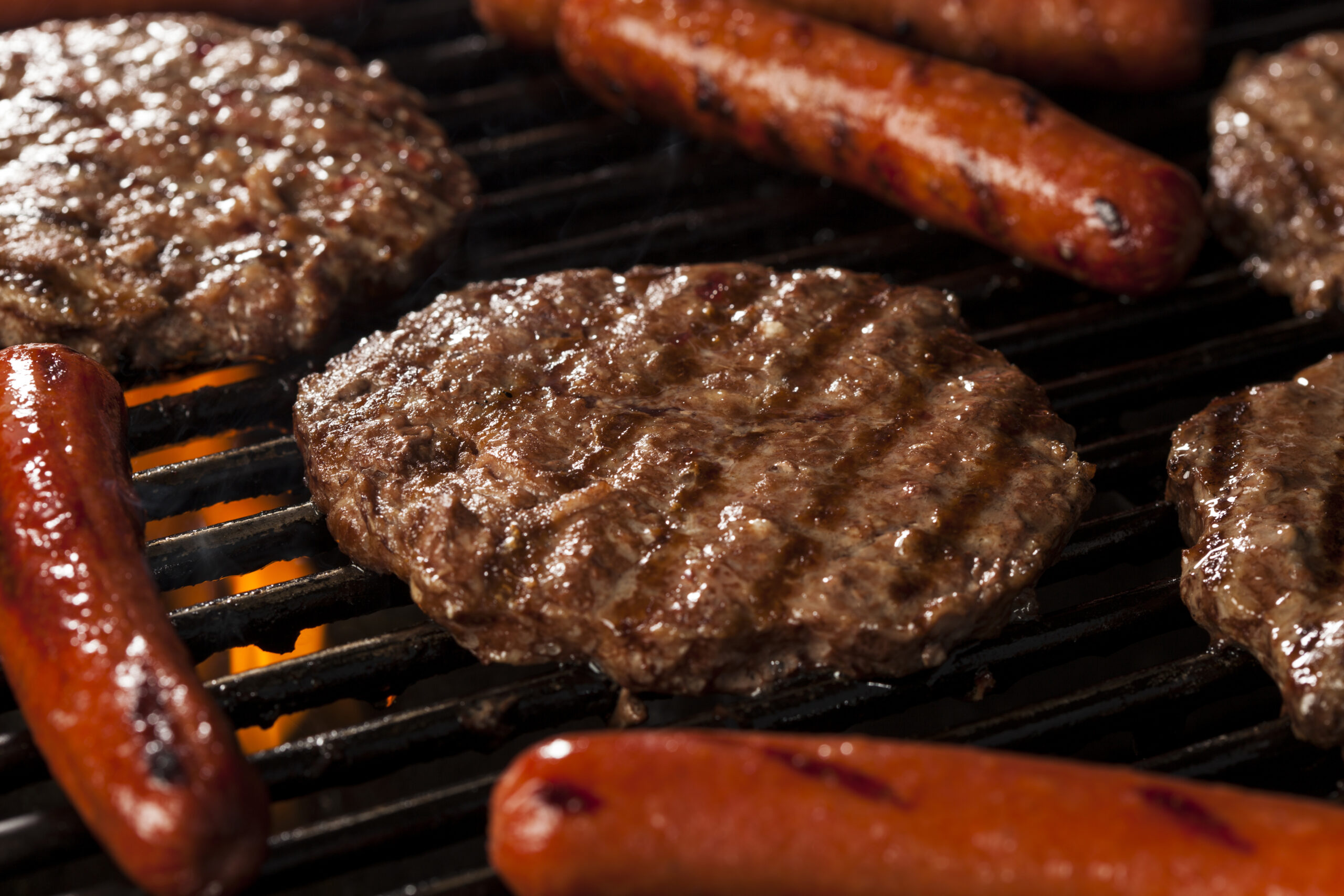 Burgers and Sausages on a barbecue grill.