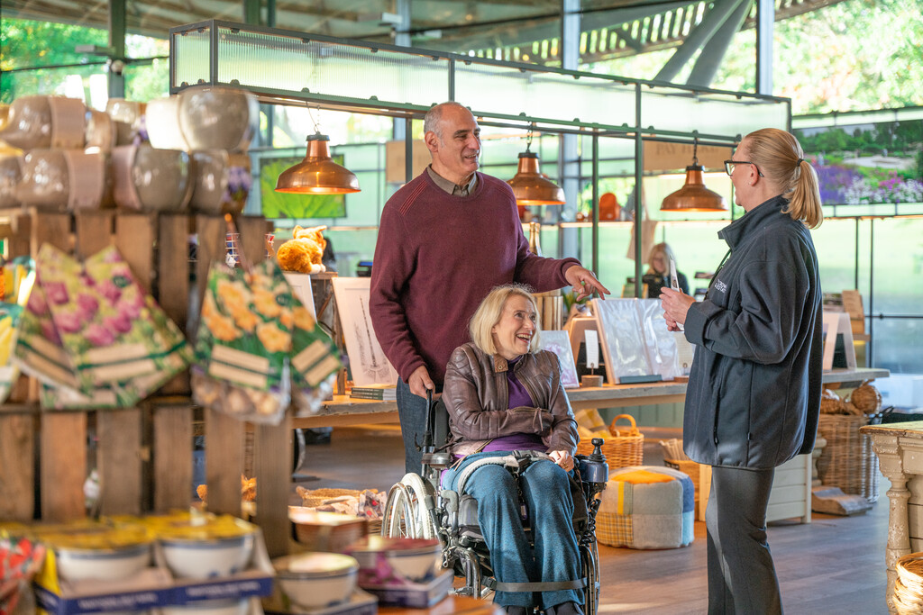Three adults chatting in a gift shop.