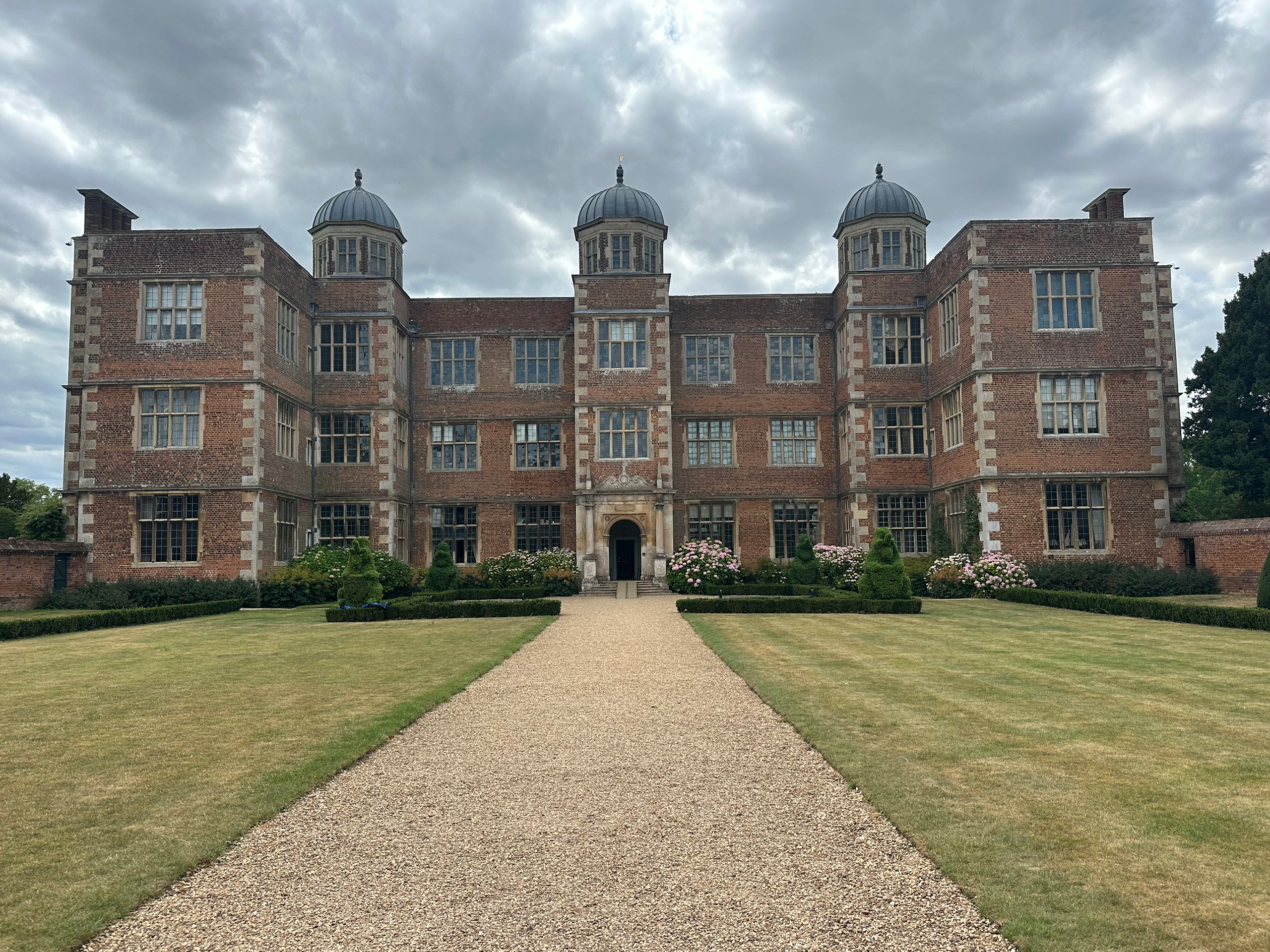 A gravel path leading to a stately house.