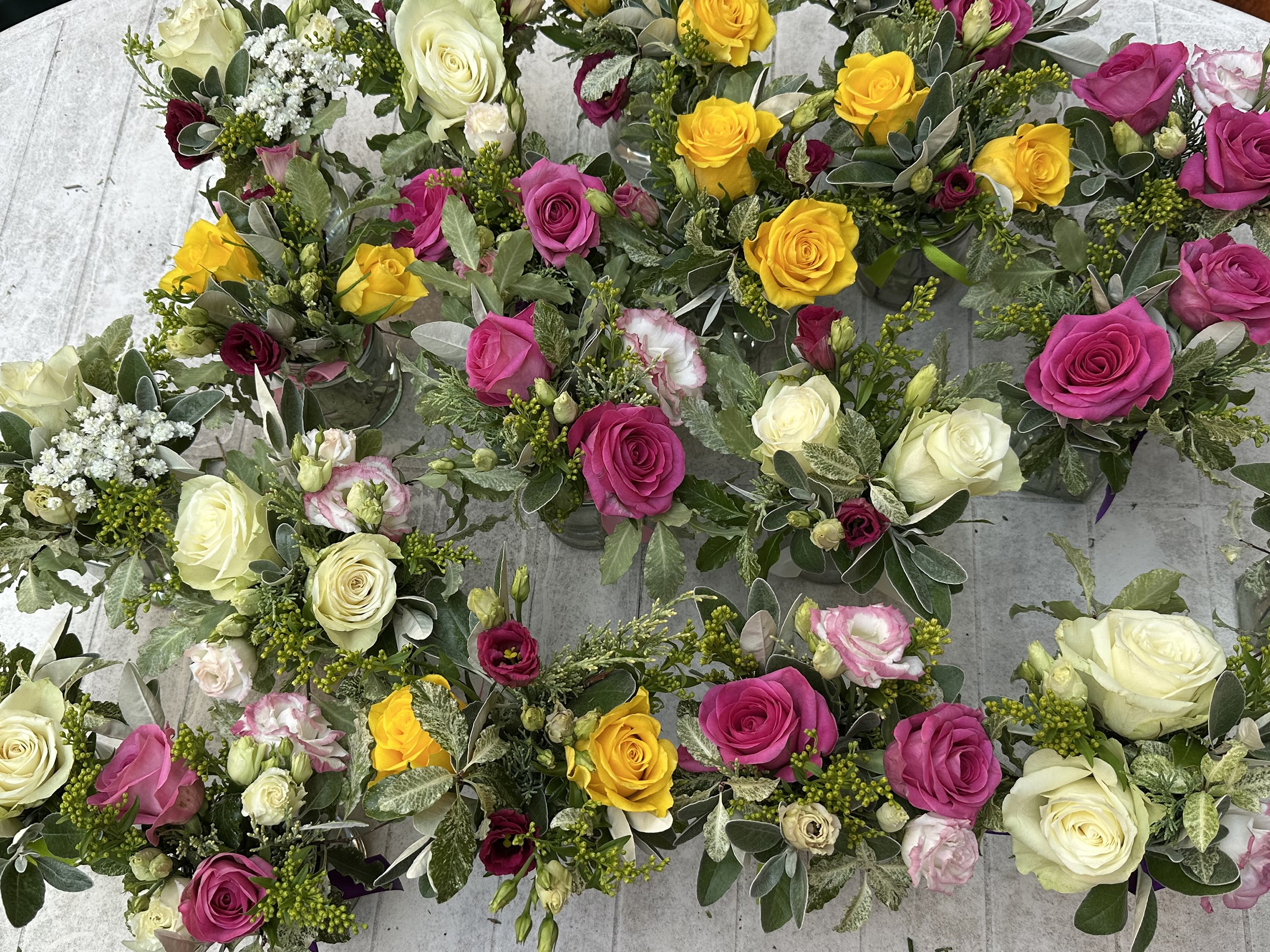 A table of small floral centrepieces.