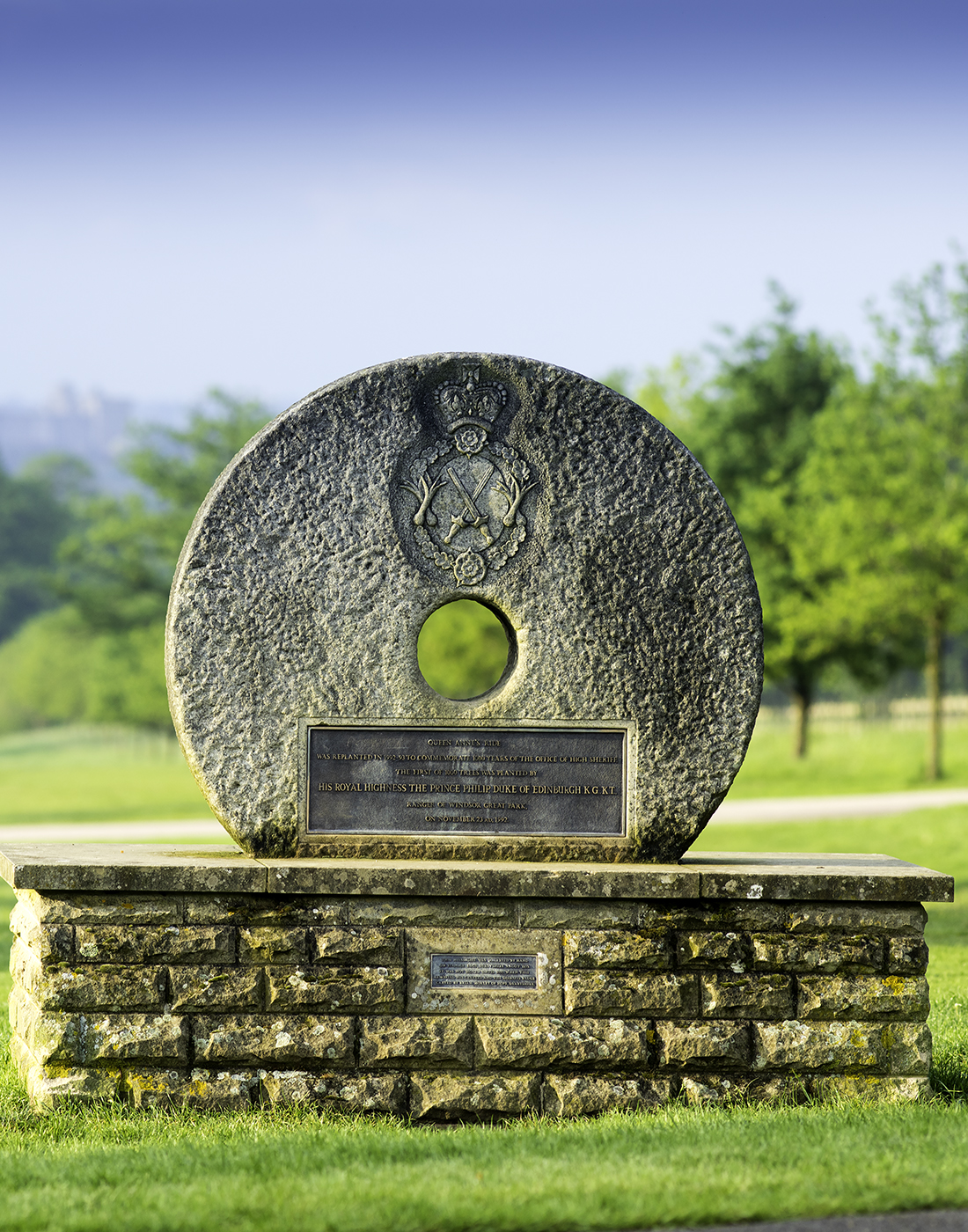 View of a circular stone on a plinth. The stone has a hold in the middle with a view to Windsor Castle.