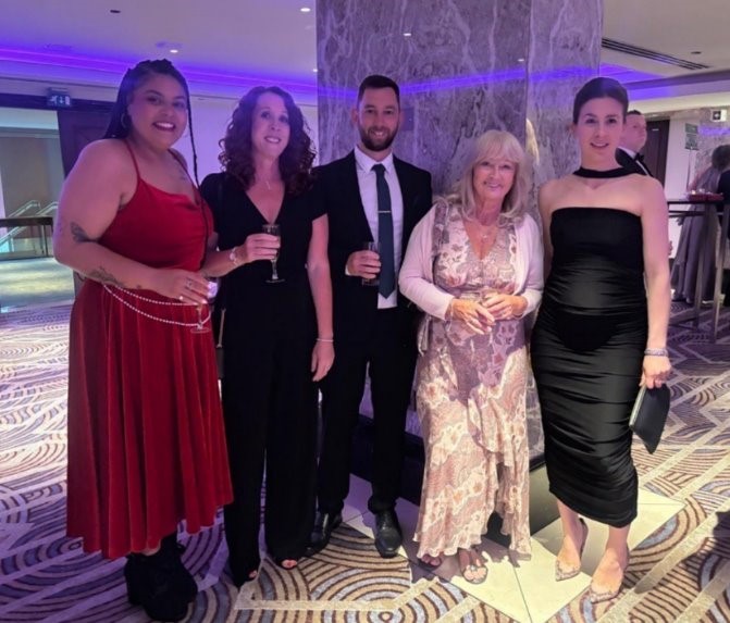 Five people dressed for an award ceremony.