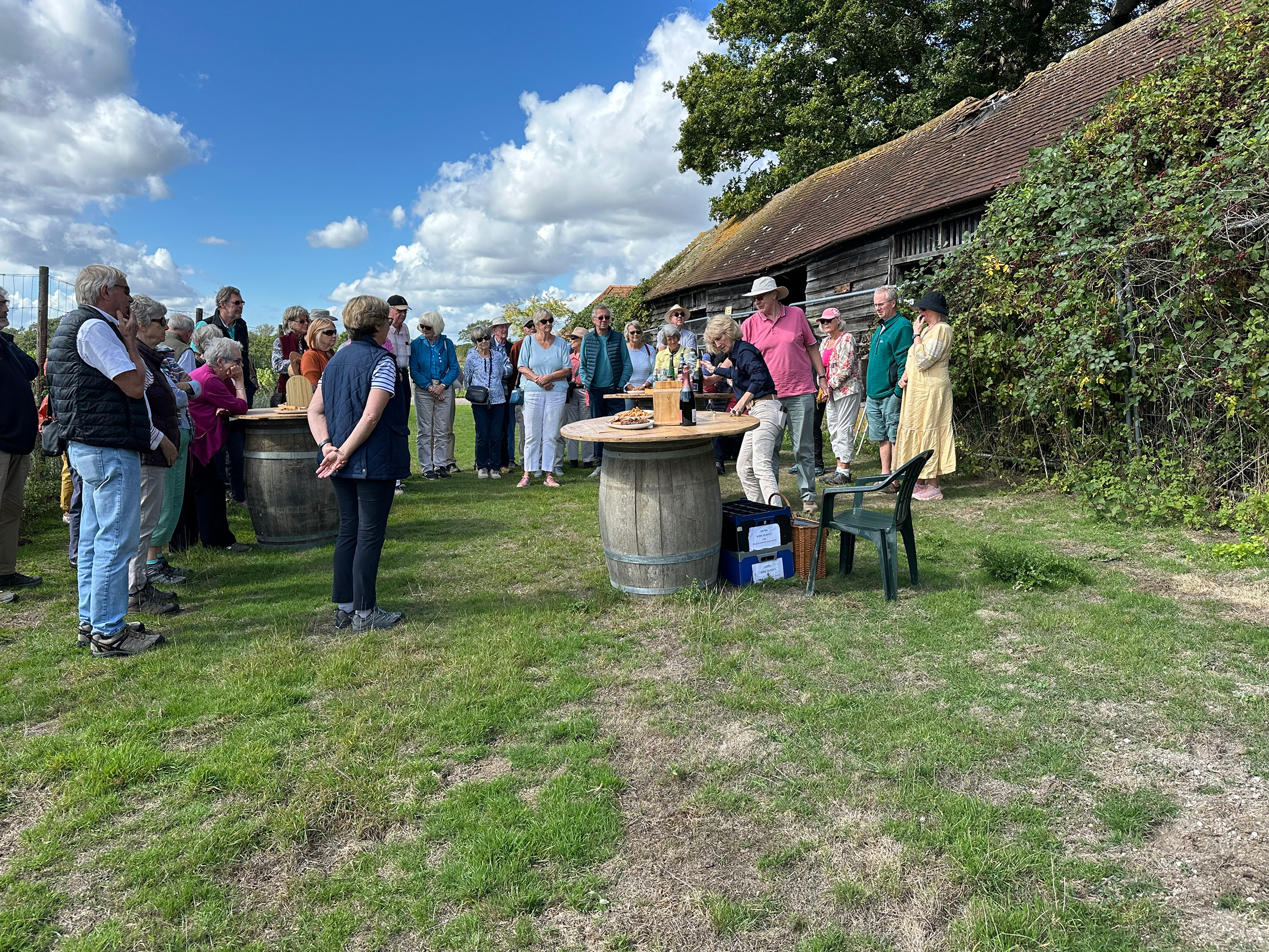 People standing outside in a semicircle listening to a speaker.