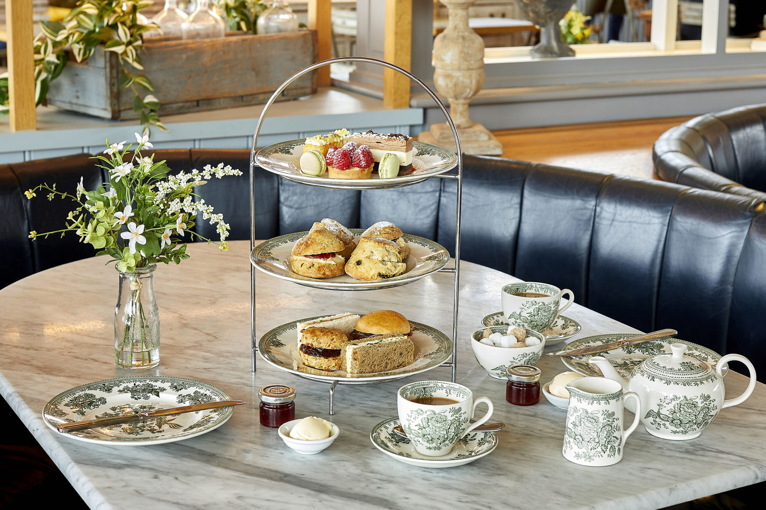 An Oak table set with an Afternoon Tea of Sandwiches, Scones, Cakes and Tea.