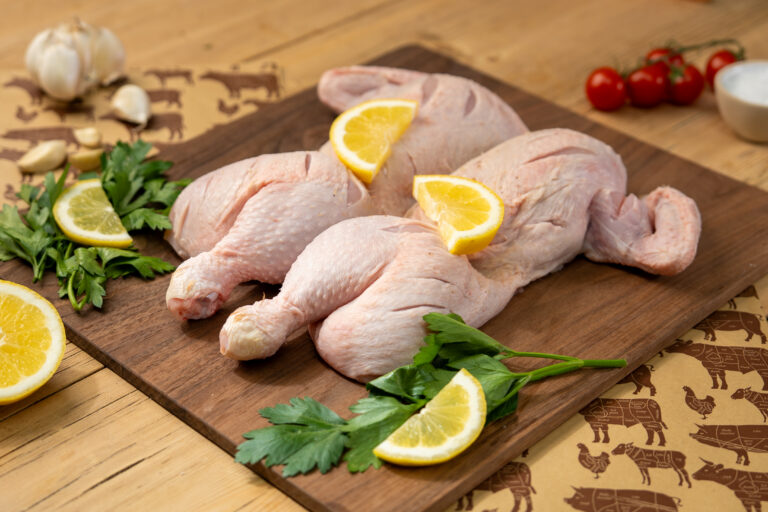 Spatchcocked Chicken with seasoning and lemon slices.