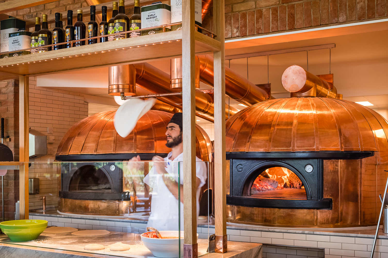 Two copper-clad wood burning pizza ovens.