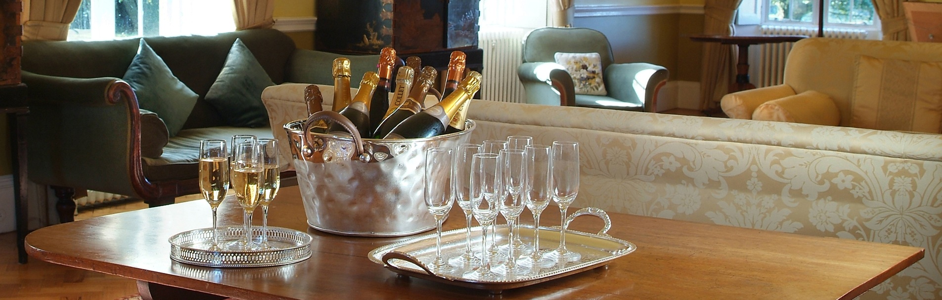 A bucket of champagnes alongside a tray of glasses.