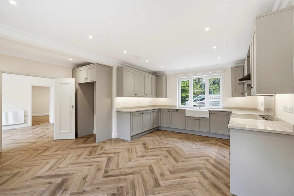 Modern fitted kitchen with shaker-style units, stone-effect worktops and integrated storage.