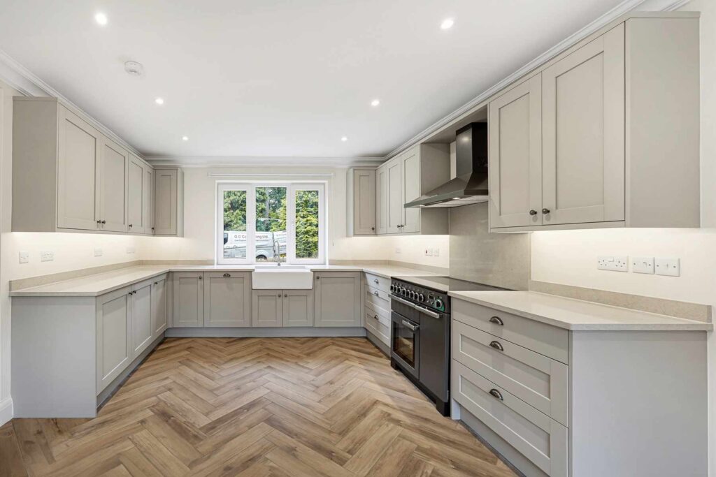 Contemporary kitchen with range-style cooker, extensive cabinetry and large farmhouse sink.
