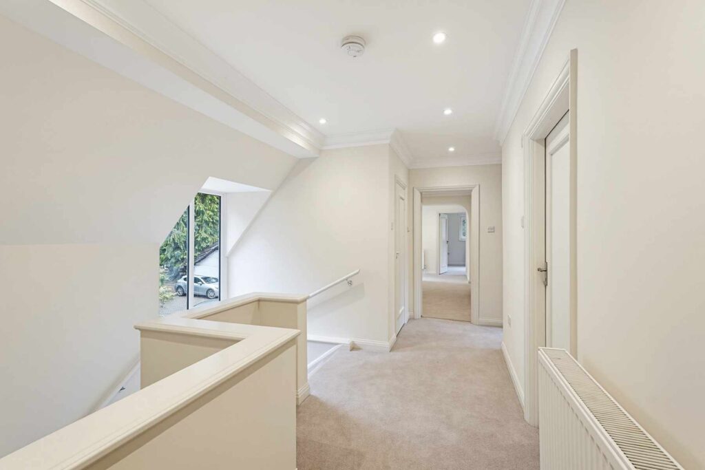First-floor landing with carpeted staircase, large window and access to bedrooms and bathrooms.
