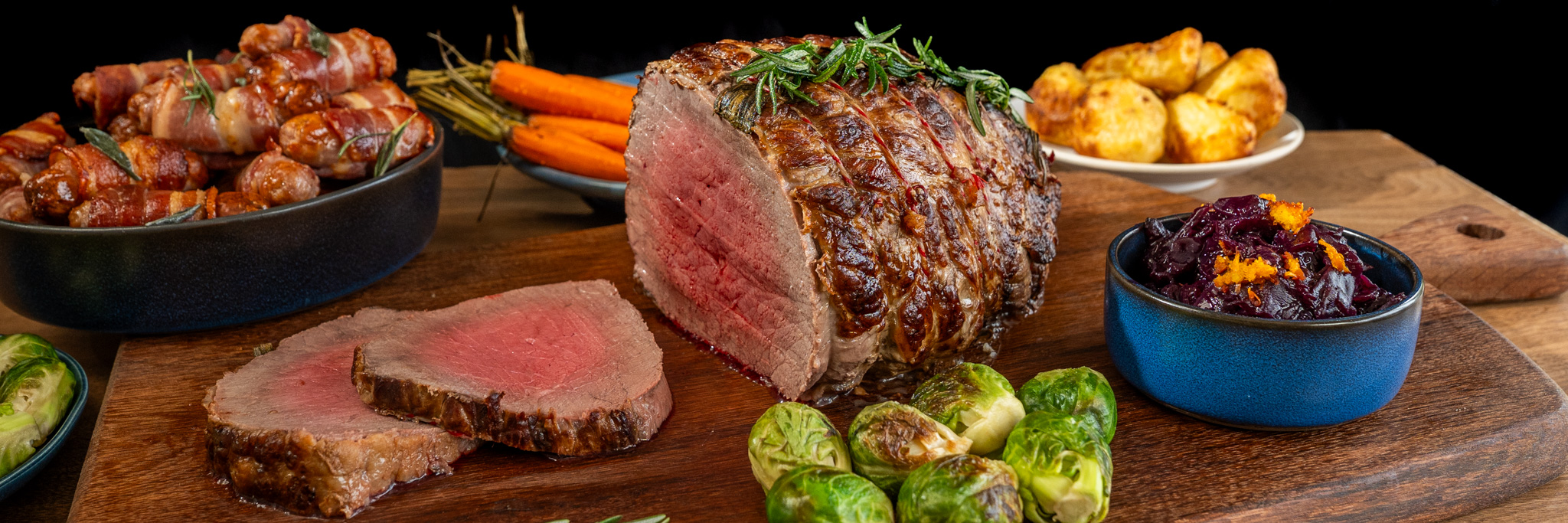 Cooked Topside of Beef with roast potatoes, carrots, sprouts and red cabbage.